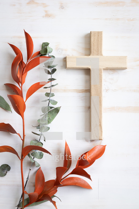 Cross and autumn leaves on a white background