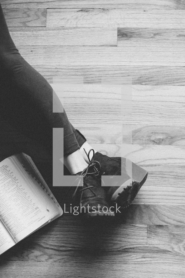 legs stretched out reading a Bible 