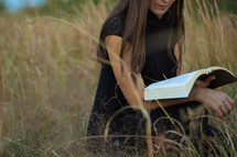 woman reading a Bible in a field