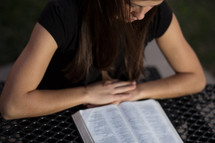 Woman reading Bible outdoors