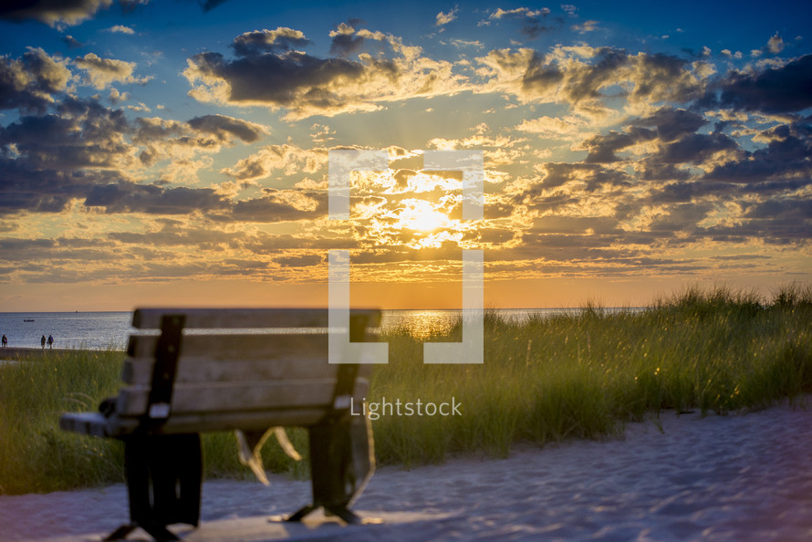 bench on a beach at sunset 