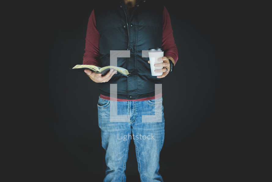 man holding a Bible and coffee cup 