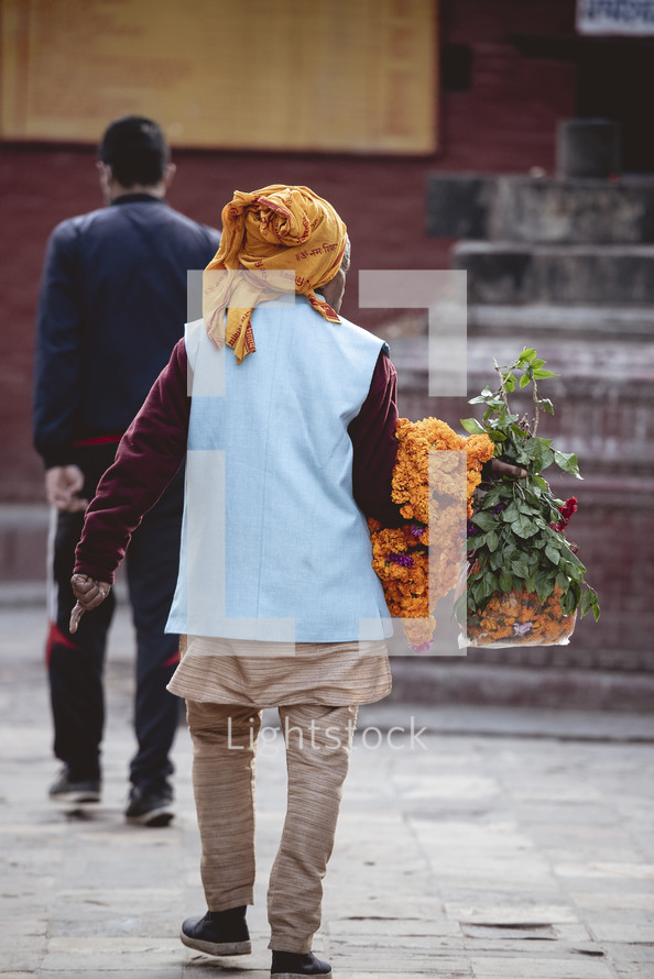 man with a banner of flowers in Nepal 