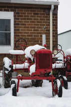 A vintage red tractor in the snow