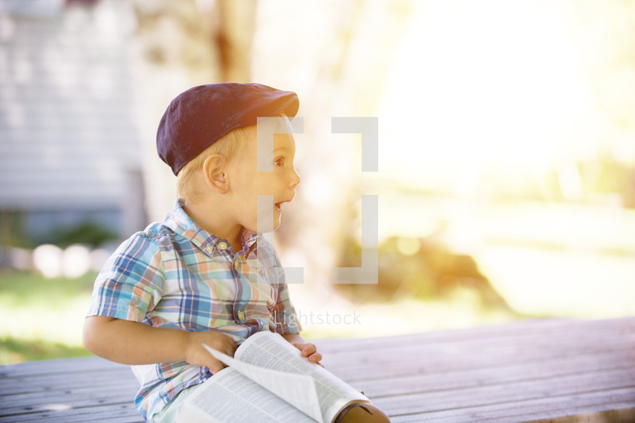 toddler boy with a Bible on his lap 