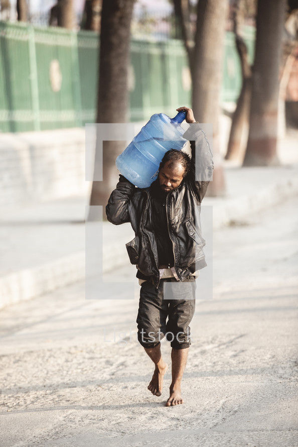 man carrying a jug of water 