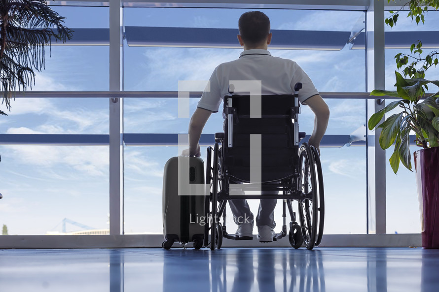 Young man in a wheelchair at the airport	
