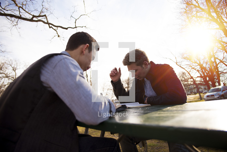 men reading Bibles outdoors 