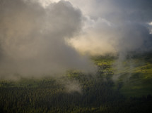 clouds over a green mountain landscape 