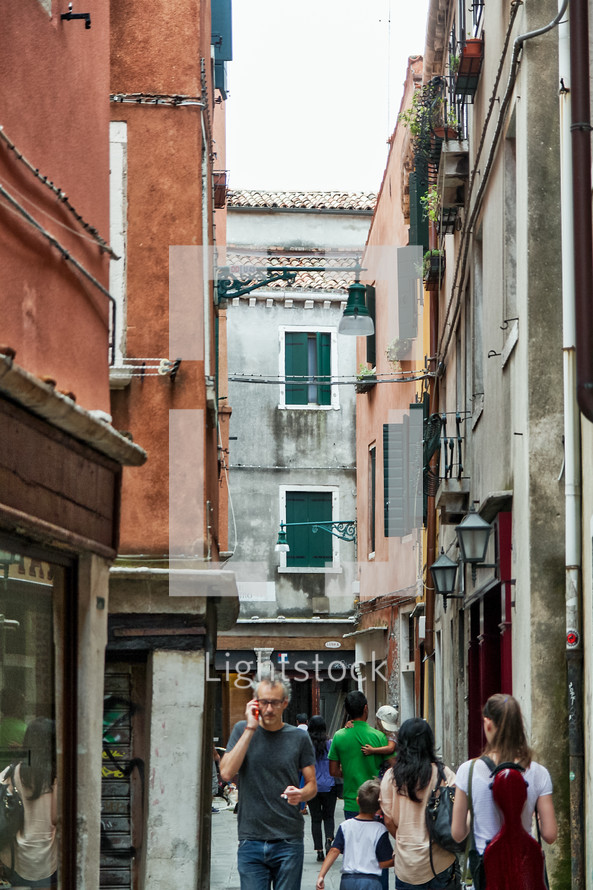 pedestrians walking the narrow alleys of Venice 