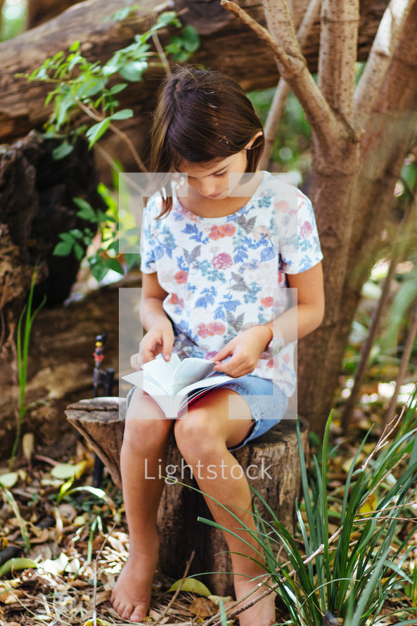girl child reading outdoors 