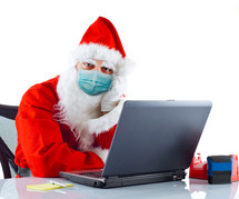 Santa Claus shopping online wearing a face mask 