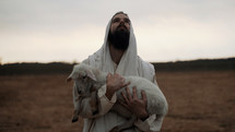 Jesus Christ as the good shepherd holding a lamb in his arms.
