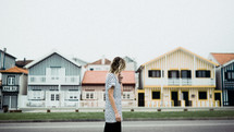 woman walking on a street in front of beach houses 