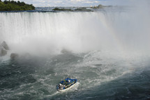 Boat approaching the foot of Niagara Falls waterfall 