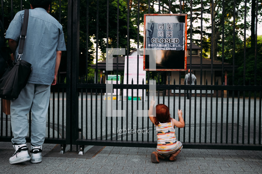 toddler looking through a gate 