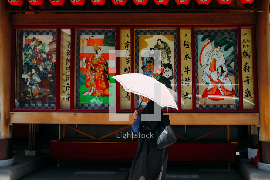 a woman walking carrying an umbrella in Japan 