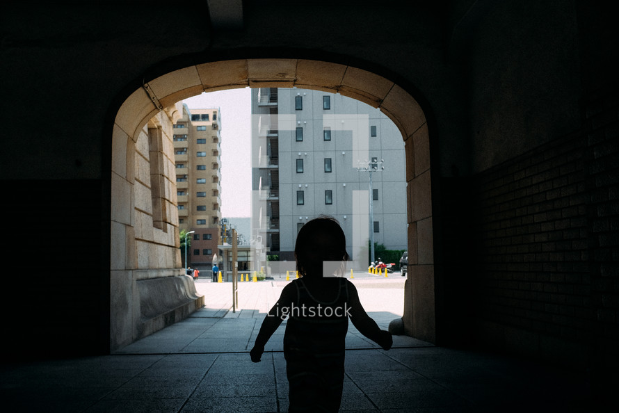 child running through a tunnel in a city in Japan 