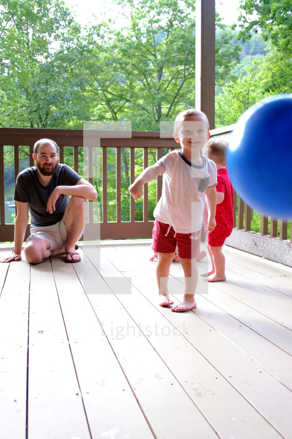 dad and children playing on a deck 