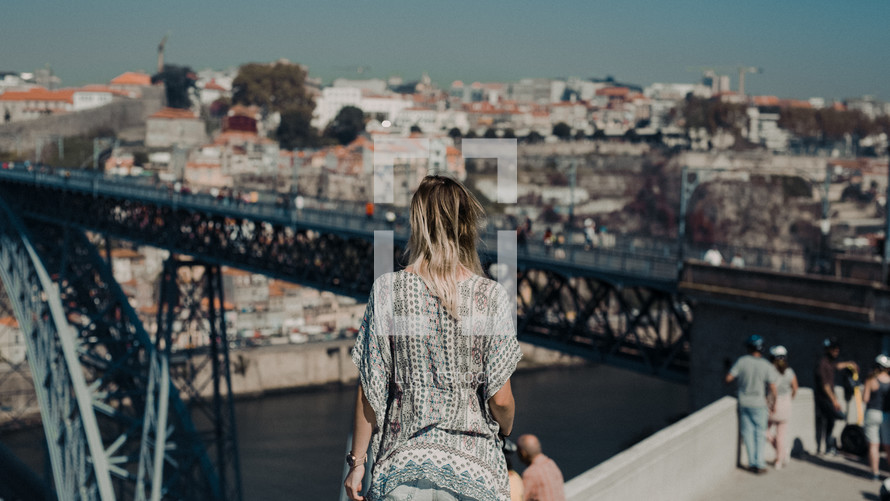 a woman on a bridge taking in the view 