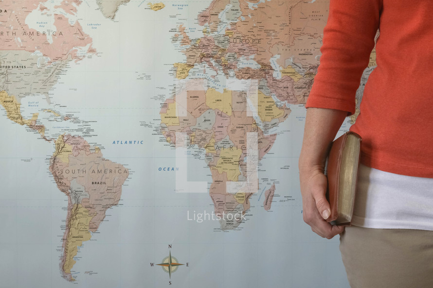 world map and woman holding a Bible 