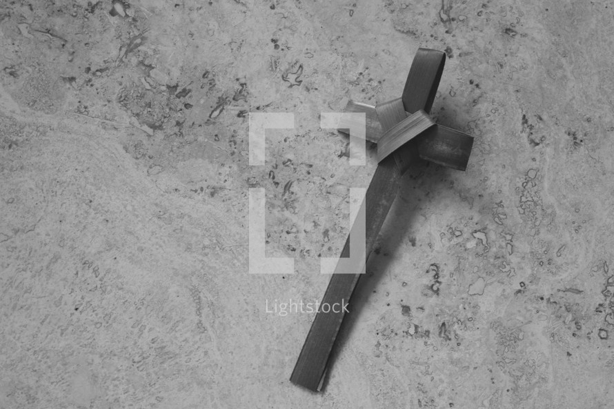 black and white palm frond cross on stone for Palm Sunday 