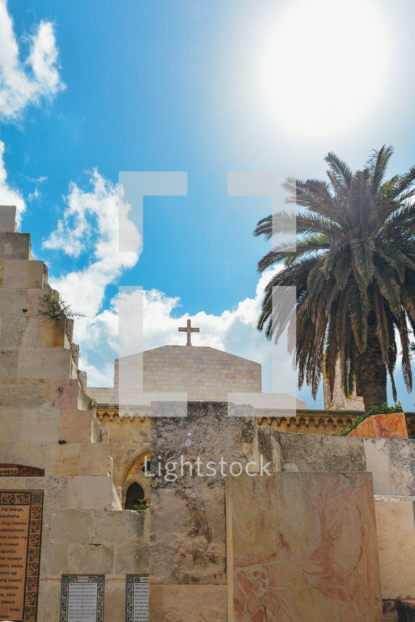 palm tree and cross on a historic stone church 