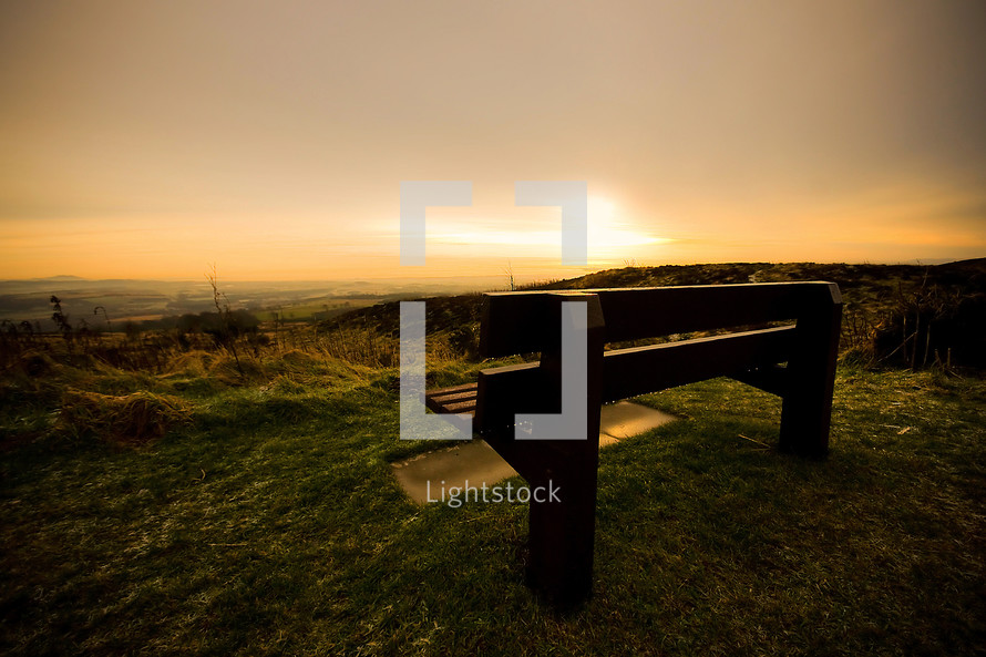 bench on a hill at sunset 