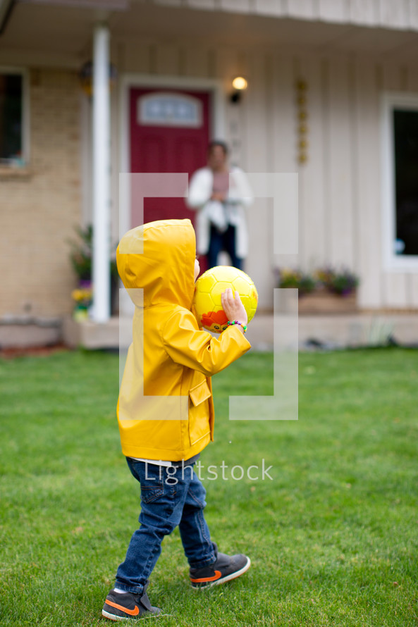 Child playing with a ball in front yard 