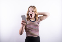 teen girl looking at a cellphone and yawning 