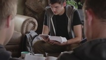 young men and women reading a Bible at a Bible study 
