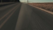 Driving on an empty desert road.