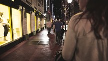 people walking down a sidewalk at night in Fort Worth 