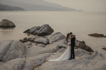 bride and groom on rocks in a bay 