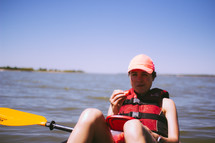 woman eating a snack on a kayak 