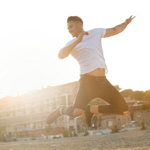 Portrait at sunset of a young man jumping with energy.