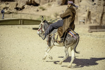 Man with head scarf on a donkey