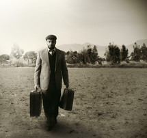 a man walking carrying luggage 