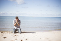 man praying on a beach 