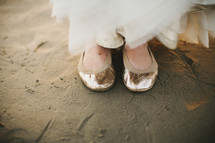 woman in ballet flats standing in the sand