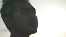 Portrait Asian Indonesian Male Hopeful Thoughtful and Confident Face Illuminated by The Sun in Dramatic Slow Motion