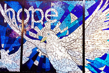 Hope in the Holy Ghost - The Word Hope with the Holy Ghost in the form of a dove stained glass window with white and blue stained glass. 