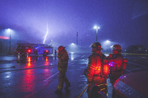 fire fighters standing outdoors and a lightning strike 
