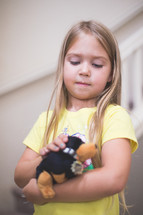 Young girl plays with a stuffed toy.