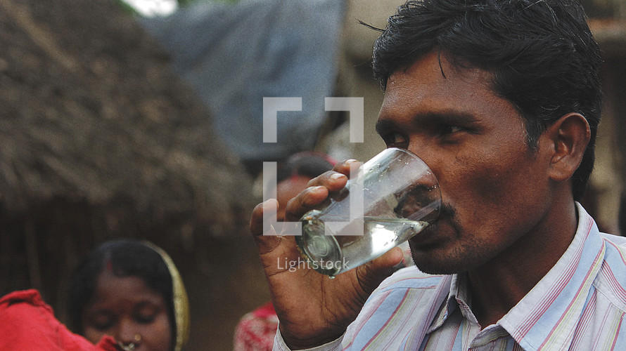 man drinking clean water in a rural Indian village 