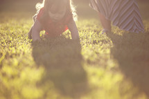 toddler girl crawling in the grass 