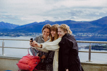 friends taking a selfie with mountains in the background 