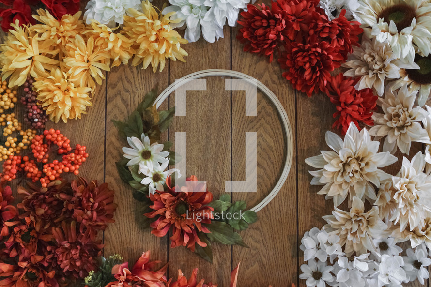 artificial fall flowers and wreath on a table