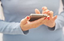 a woman with painted nails using a cellphone 