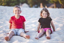 kids sitting in the sand 